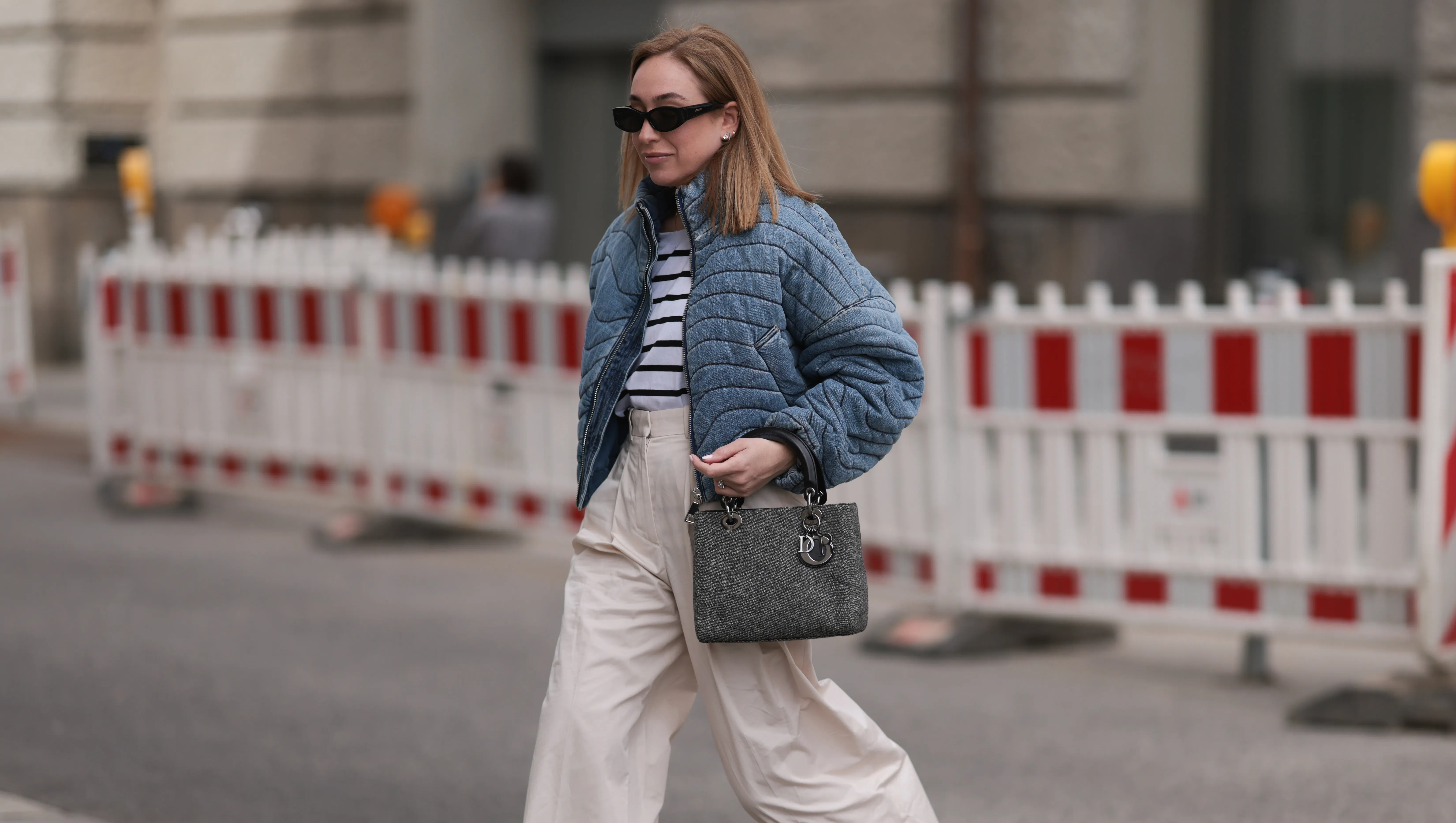 BERLIN, GERMANY - APRIL 04: Sonia Lyson seen wearing Jacquemus black sunglasses, Zara white striped cotton t-shirt, Khrisjoy blue denim striped short jacket, COS creamy white / beige linen long pants, Dior grey denim fabric vintage Lady Dior bag and Zara shiny black leather ballerinas, on April 04, 2024 in Berlin, Germany. (Photo by Jeremy Moeller/Getty Images)