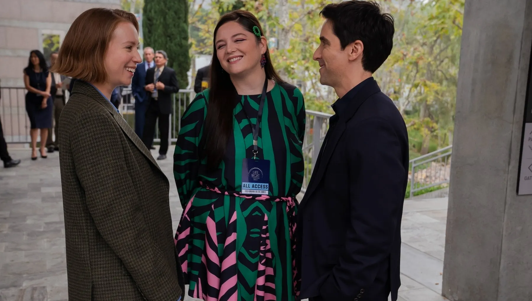 Three people stand and talk in Hacks season 4.