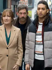 Three people stand in the street in Harry Wild.