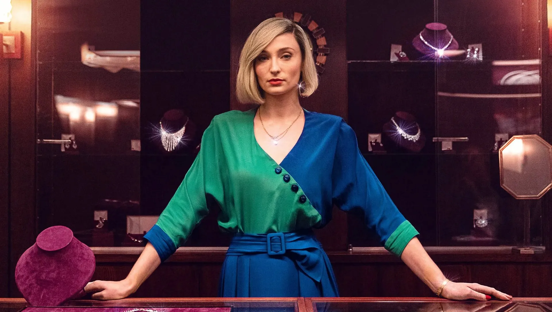 A woman stands at a shop counter in Joan.