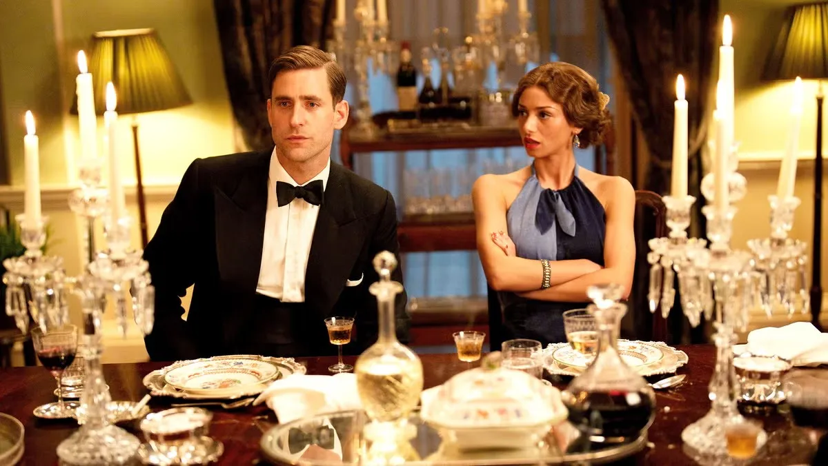 Two people sit at a dinner table in Agatha Christie's Towards Zero.