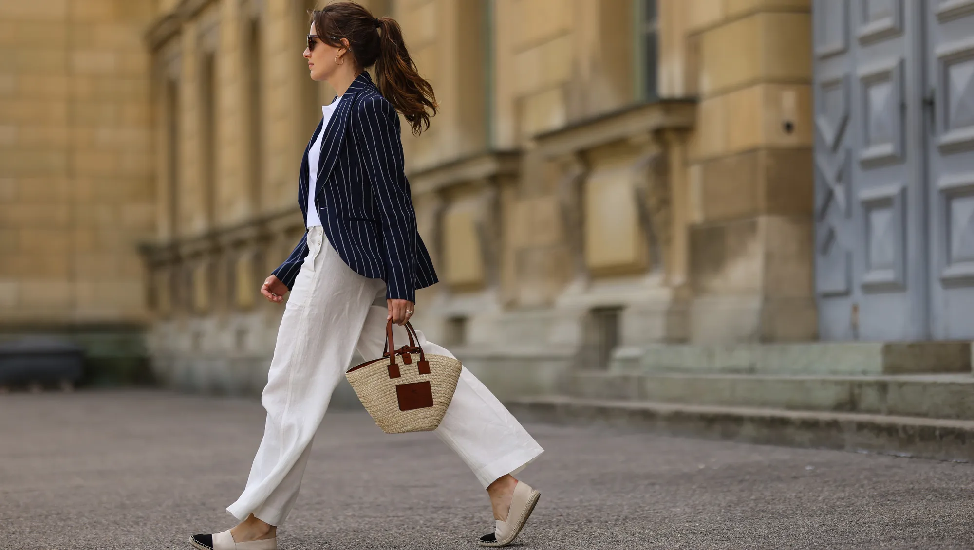 Cleo zu Oettingen-Spielberg wearing navy blue striped Polo Ralph Lauren jacket, white polo and white linen pants and beige Loewe bag via Lodenfrey SS21 on May 10, 2021 in Munich, Germany.