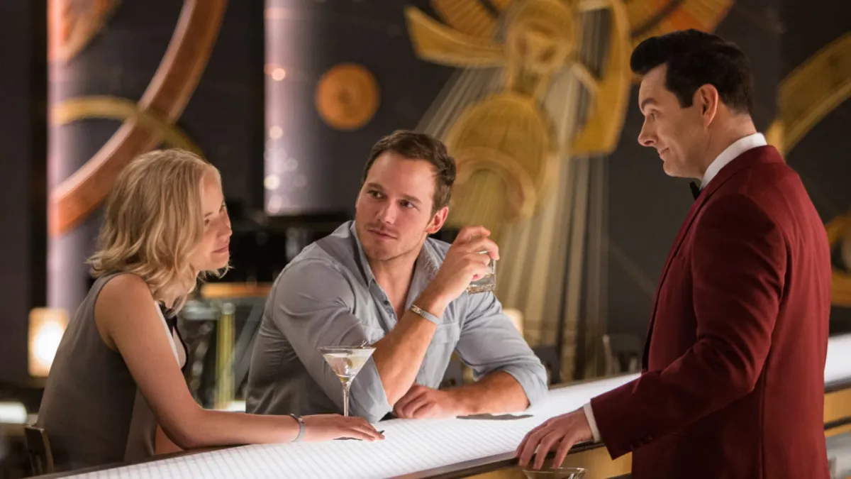 A bartender looks at a man and a woman in Passengers.