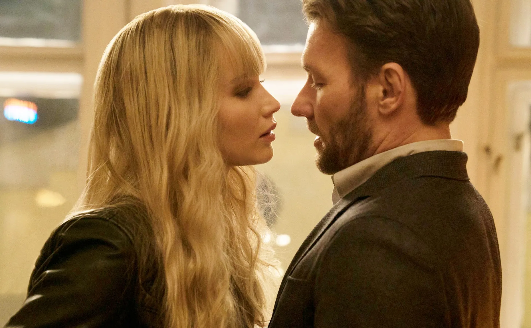 A woman leans near a man in Red Sparrow.