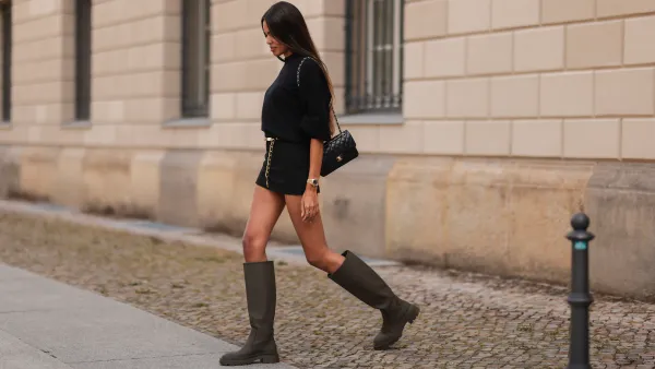 BERLIN, GERMANY - SEPTEMBER 13: Jill Asemota wearing Chanel belt, Acne Studios black Sweater, Zara black mini skirt and olive boots and Chanel black leather bag on September 13, 2021 in Berlin, Germany. (Photo by Jeremy Moeller/Getty Images)