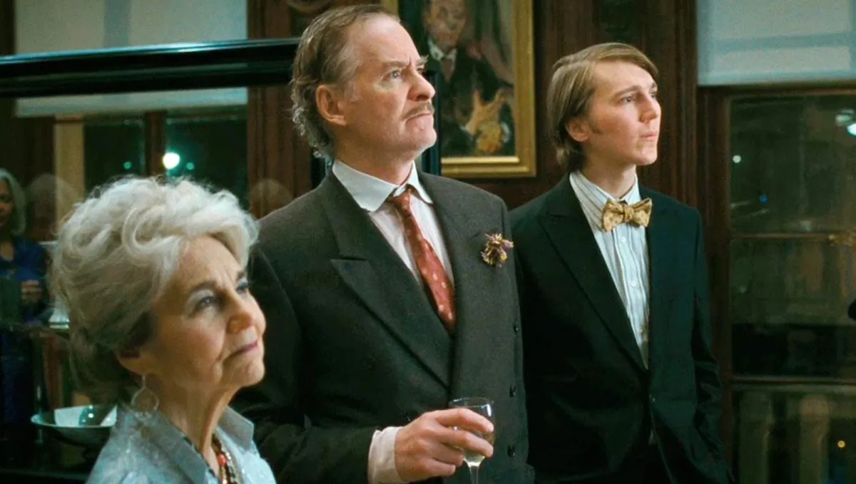 Two men and an old lady look at a picture in The Extra Man.