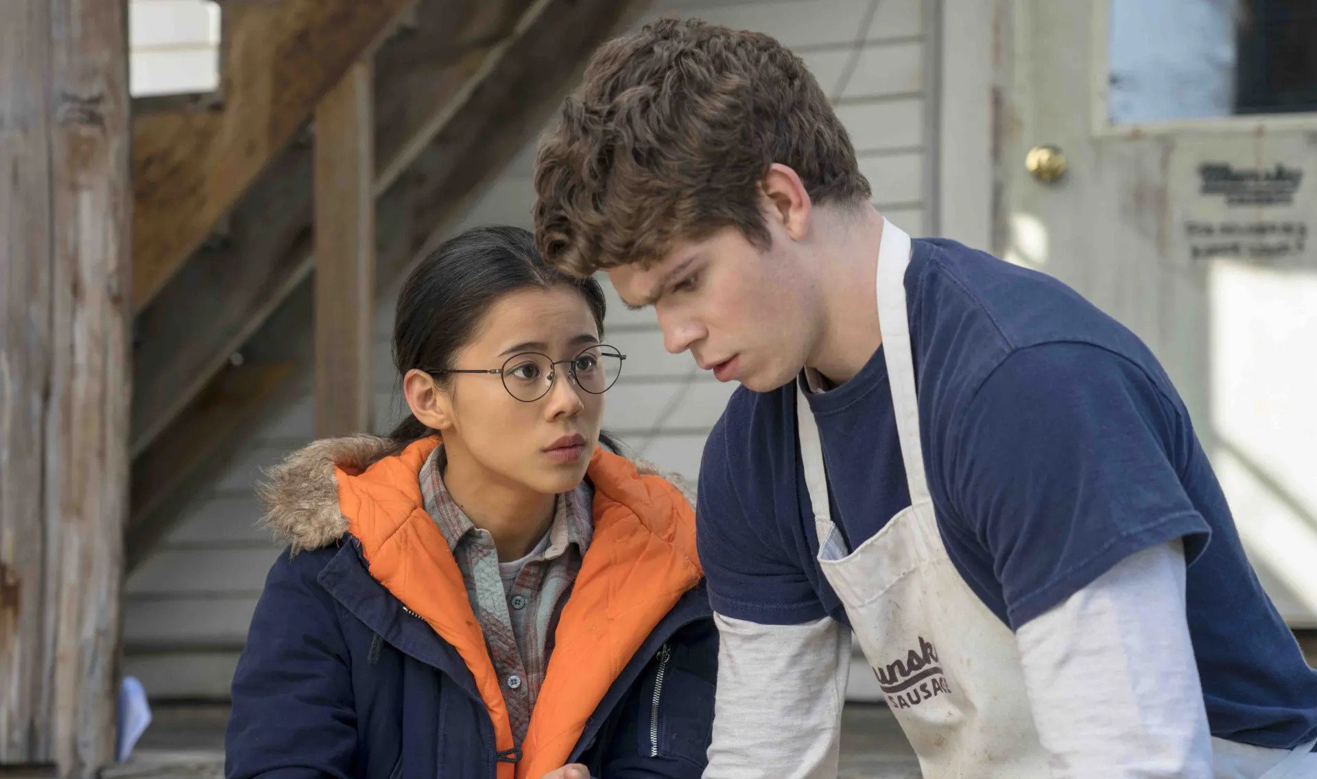 A teen girl looks at a teen boy in The Half of It.