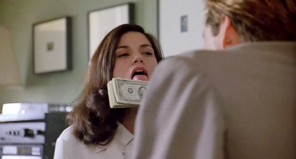 A woman licks some money in The Last Seduction.