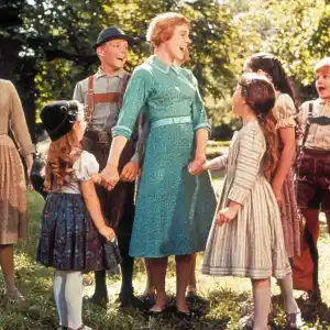 A woman is surrounded by children in The Sound of Music.