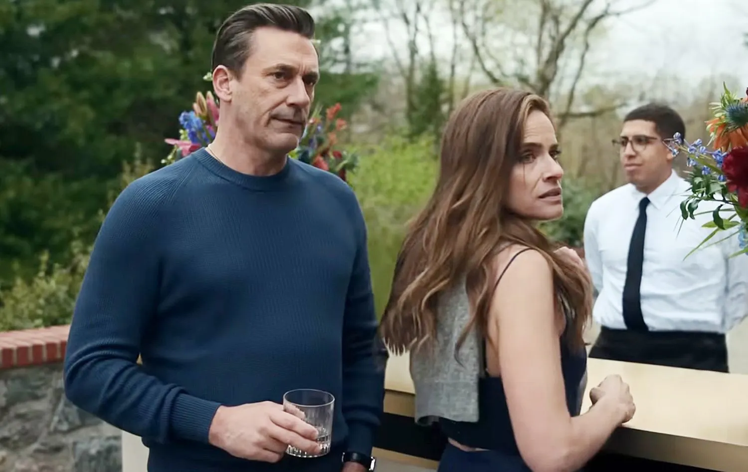 A man and a woman stand next to each other in Your Friends & Neighbors.