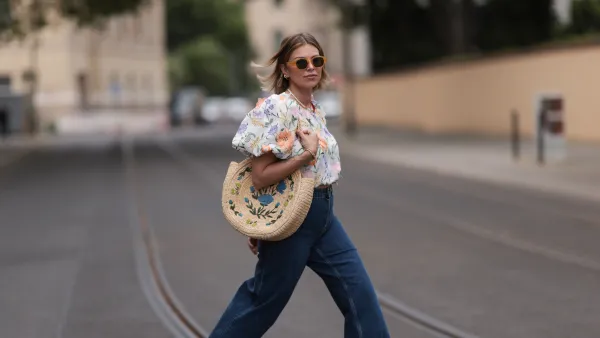 BERLIN, GERMANY - JUNE 06: Aline Kaplan wearing Baum & Pferdgarten wide leg blue denim pants, & other stories white flower pattern cropped blouse and orange summer heels and Mango orange black shades on June 06, 2023 in Berlin, Germany. (Photo by Jeremy Moeller/Getty Images)