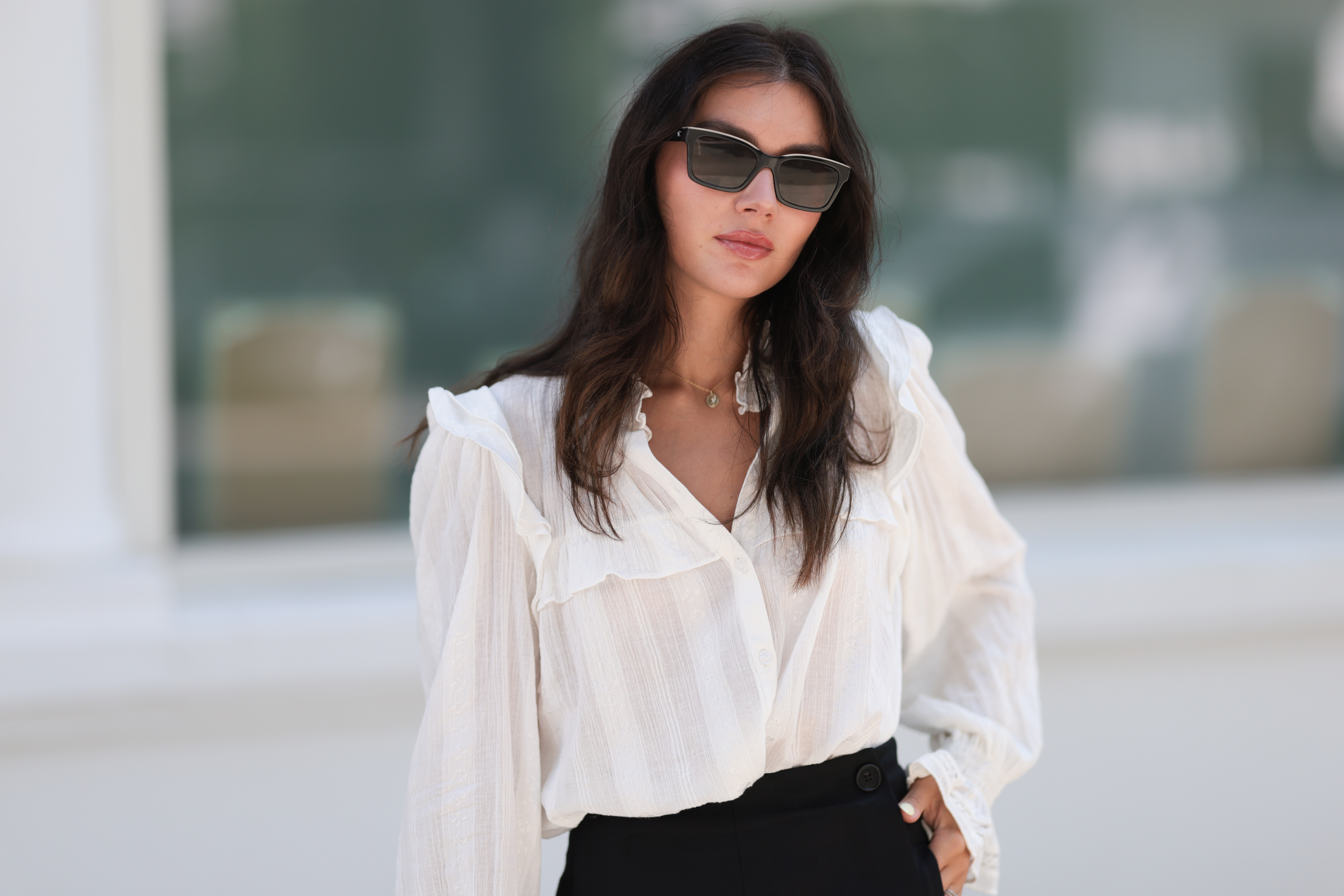 Milena Karl is seen wearing black sunglasses from Chanel, earrings from Bottega Veneta, a gold necklace, a a white shirt with puffy sleeves, black shorts from Chloe, gold and silver rings on August 22, 2023 in Hamburg, Germany.