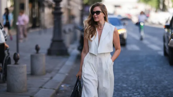 PARIS, FRANCE - JULY 07: Ginta seen wearing back sunglasses from Yves Saint Laurent, diamond stud earrings, diamond necklace, a creme white linen suit vest and matchings creme white linen suit pants from Bequartii, a black leather Hermes Birkin bag, during Paris Fashion Week - Haute Couture Fall Winter 2022 2023, on July 07, 2022 in Paris, France. (Photo by Jeremy Moeller/Getty Images)