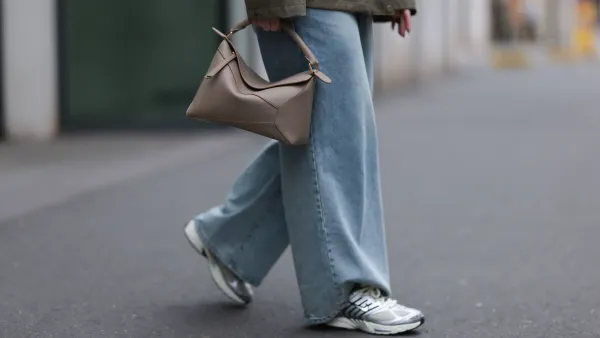 DUESSELDORF, GERMANY - MARCH 14: Maria Barteczko seen wearing g-lab olive green hooded waterproof parka jacket, The Frankie Shop blue denim used baggy jeans, LOEWE beige leather big Puzzle bag and Nike light khaki Pegasus sneaker with metallic details, on March 14, 2025 in Duesseldorf, Germany. (Photo by Jeremy Moeller/Getty Images)