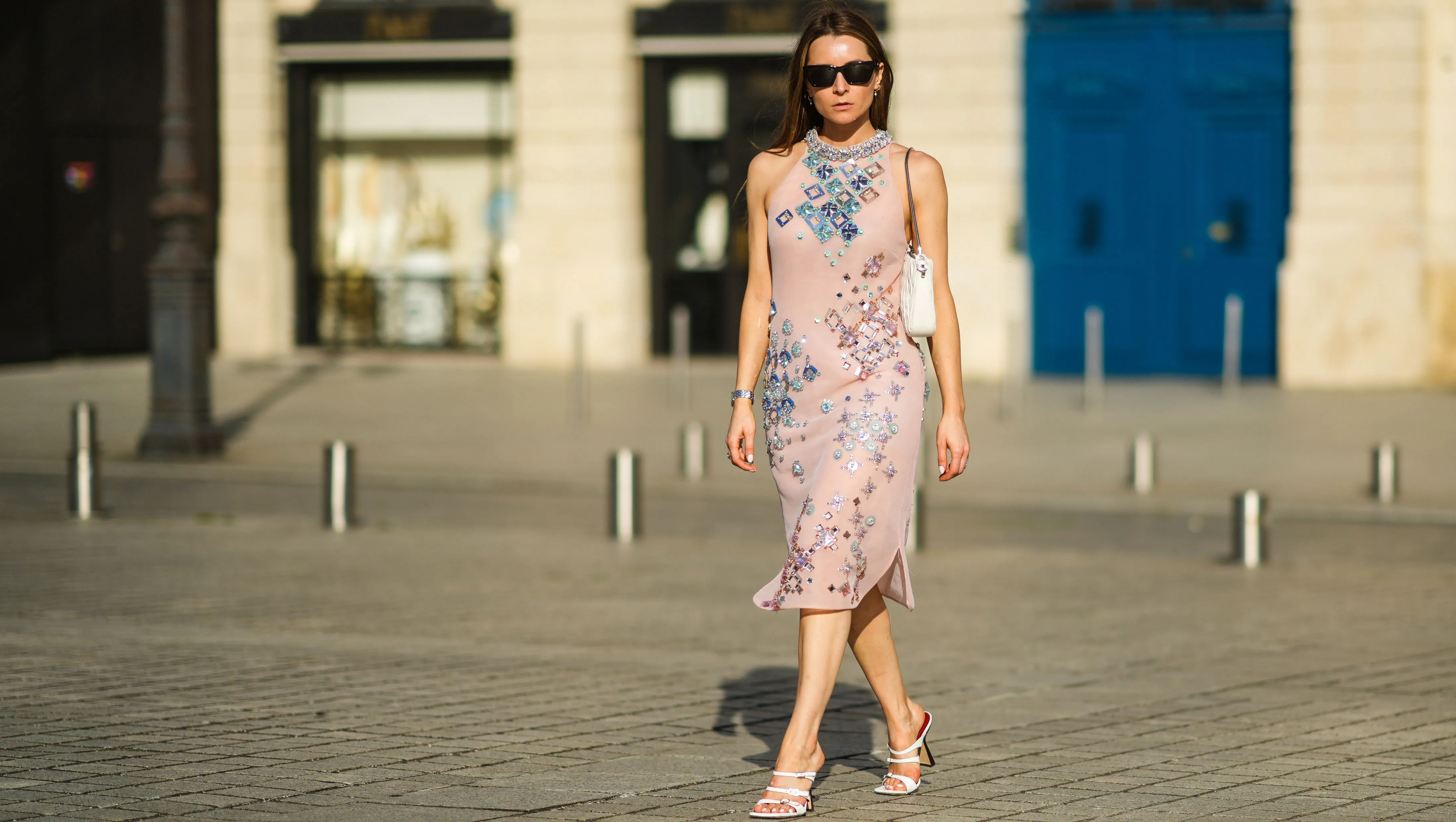 PARIS, FRANCE - JULY 15: Julia Comil wears a pink silky sheer embroidered and bejeweled midi dress from Miu Miu, a white "matelassé" nappa quilted leather Bag from Miu Miu, cat-eye sunglasses by Saint Laurent, white square toe heeled sandals from By Far, on July 15, 2021 in Paris, France. (Photo by Edward Berthelot/Getty Images)