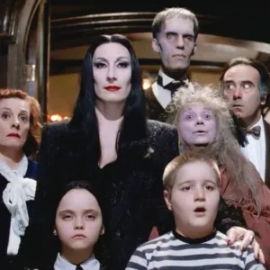 A kooky family stands in a doorway in 'The Addams Family.'