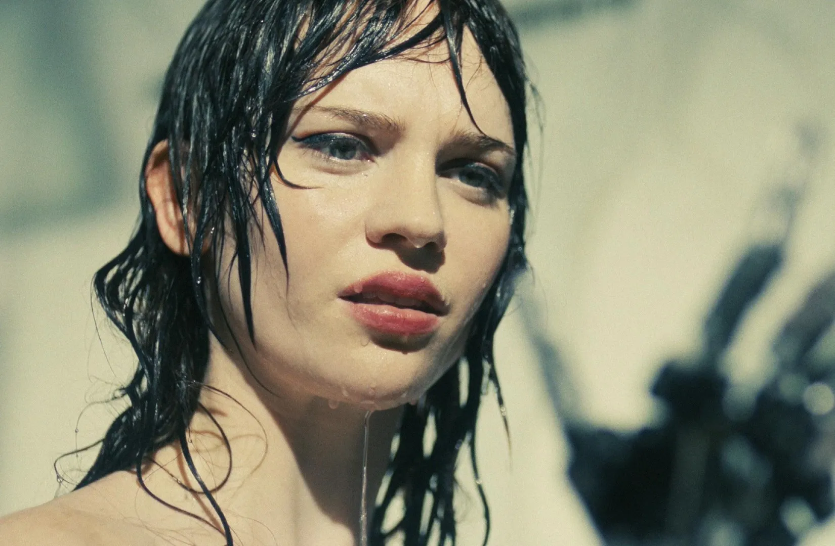 A woman in a shower looks at her hand in 'Companion.'
