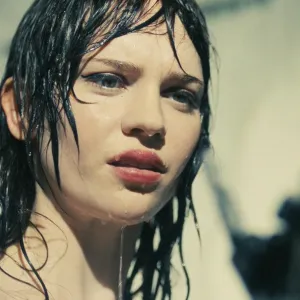 A woman in a shower looks at her hand in 'Companion.'