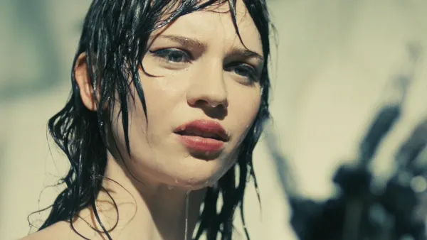 A woman in a shower looks at her hand in 'Companion.'