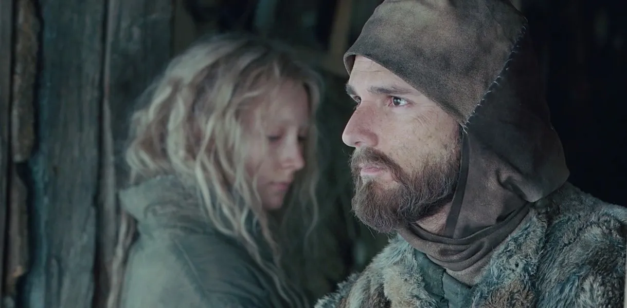 A man and a girl look in opposite directions in 'Hanna.'