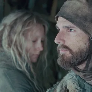 A man and a girl look in opposite directions in 'Hanna.'