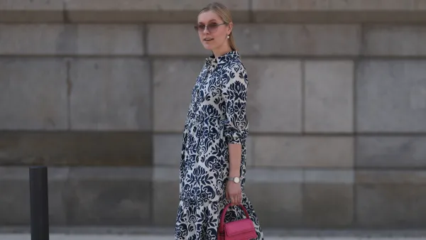 HAMBURG, GERMANY - JUNE 08: Lil Paulin seen wearing a darkblue and white flower printed long dress, pink mini handbag, Emporio Armani brown big shades, Daniel Wellington silver watch, Superga navy blue sneaker and silver pearls earrings and rings on June 08, 2023 in Hamburg, Germany. (Photo by Jeremy Moeller/Getty Images)