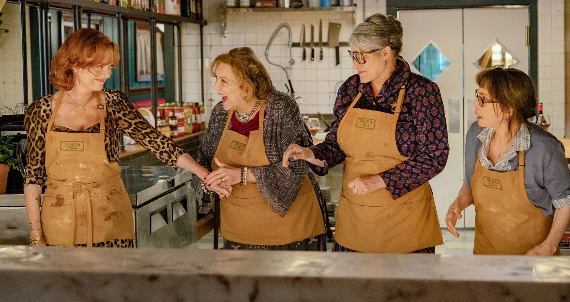 Four older women stand in a kitchen in 'Nonnas.'