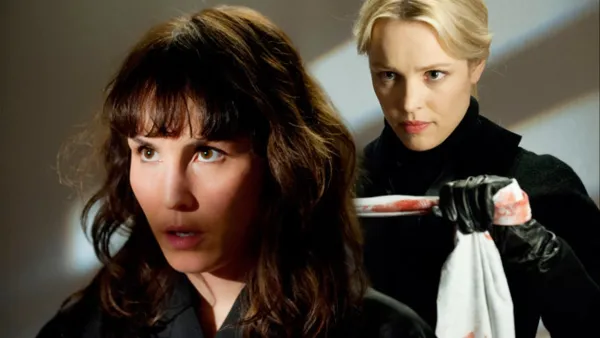 A woman stands behind another woman in 'Passion.'