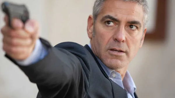 A man points his gun in 'The American.'