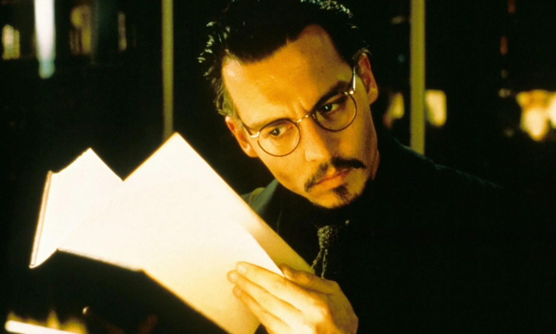 A man looks at a book in 'The Ninth Gate.'