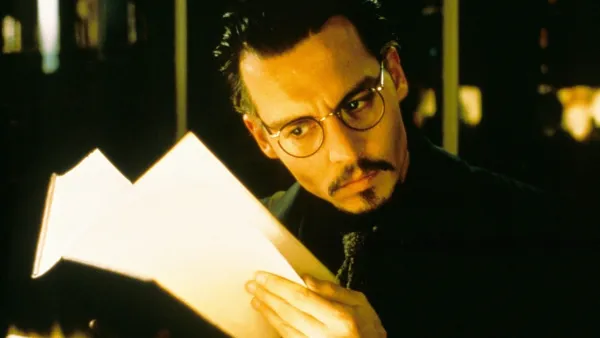 A man looks at a book in 'The Ninth Gate.'