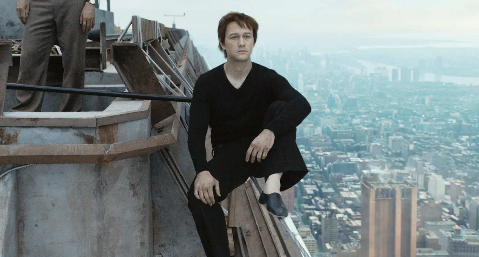 A man sits on a building beam in 'The Walk.'