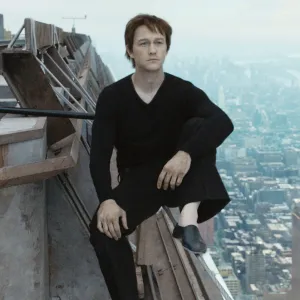 A man sits on a building beam in 'The Walk.'