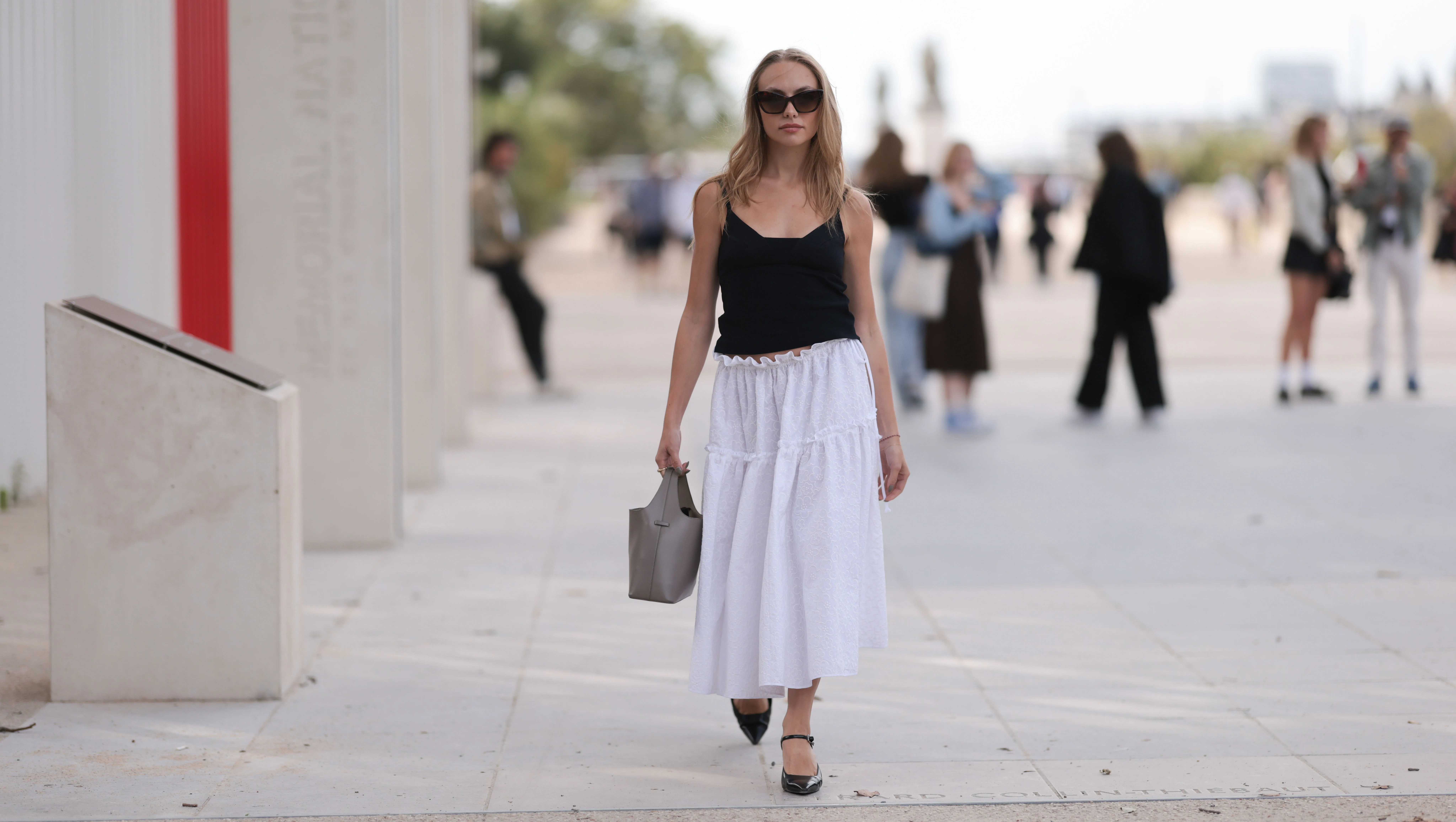 PARIS, FRANCE - SEPTEMBER 28: Guest is seen outside Chloe show wearing black sunnies, black tank top, white ruffled long skirt, taupe colored handbag and black leather ballet flats during the Womenswear Spring/Summer 2024 as part of Paris Fashion Week on September 28, 2023 in Paris, France. (Photo by Jeremy Moeller/Getty Images)