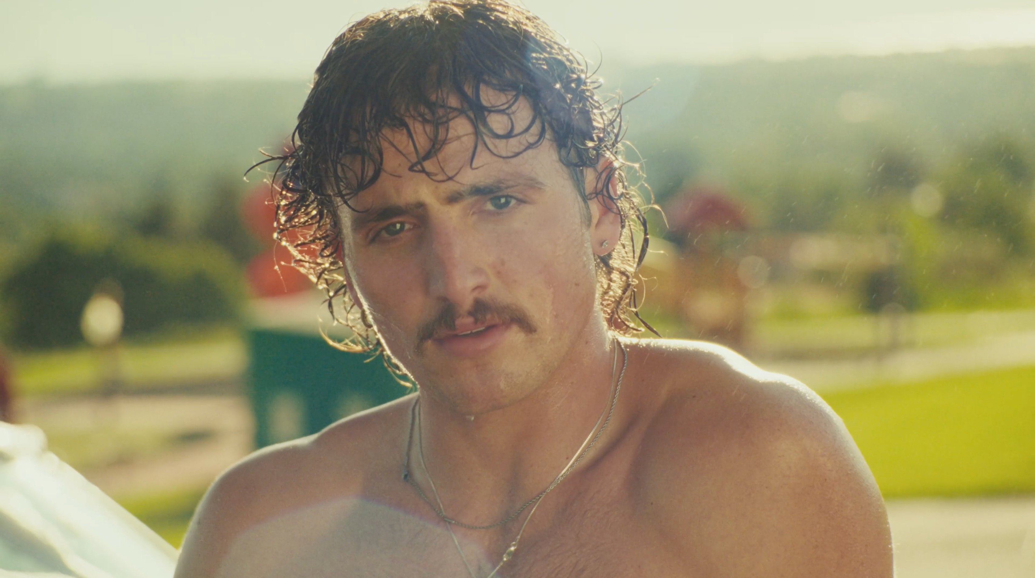 Benson Boone shirtless in his "Mr. Electric Blue" music video