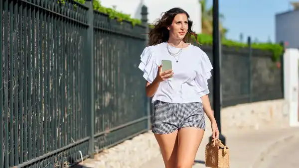 Woman walking on the street with smartphone in hand - stock photo