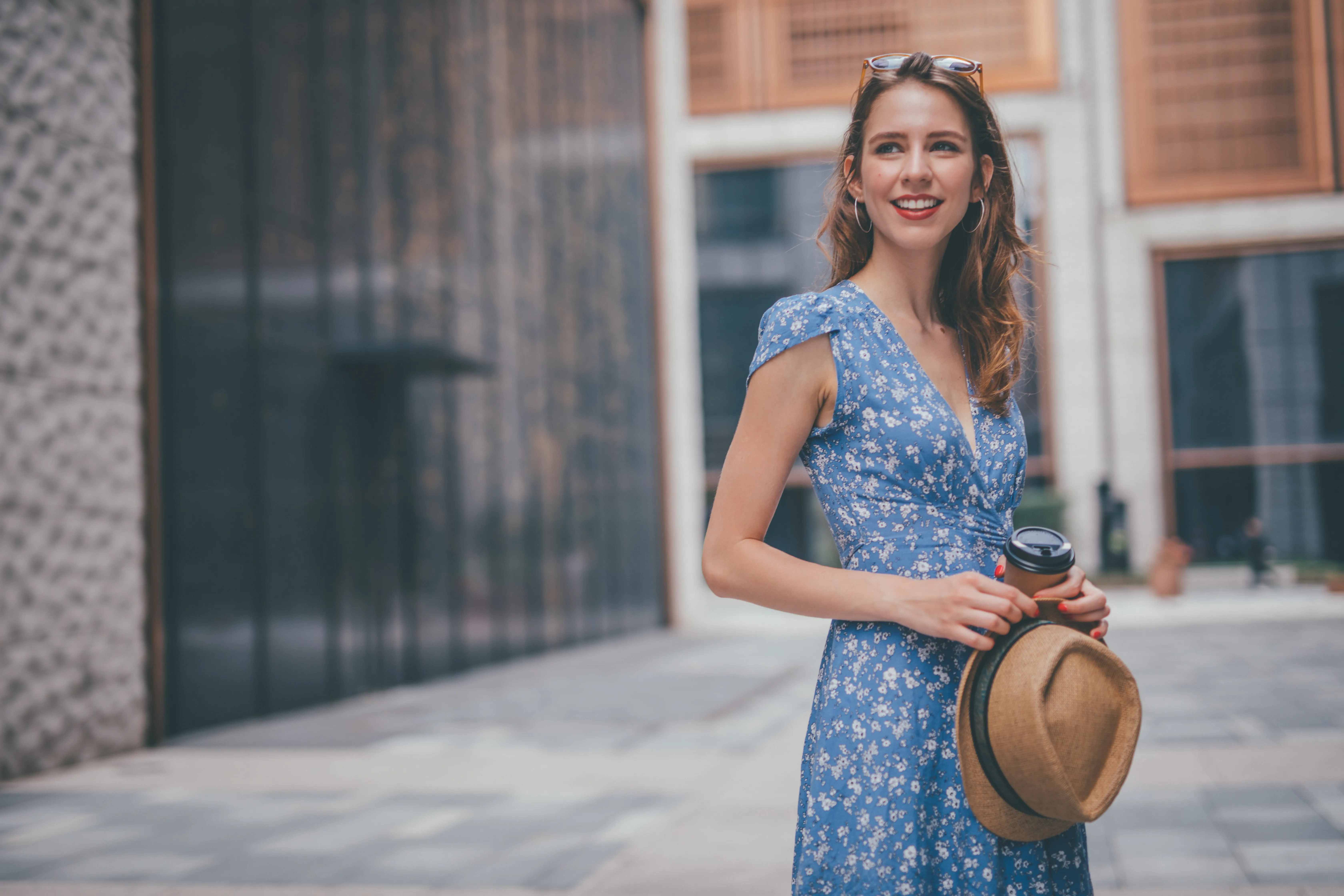One woman, cute young woman in city, holding a coffee cup.