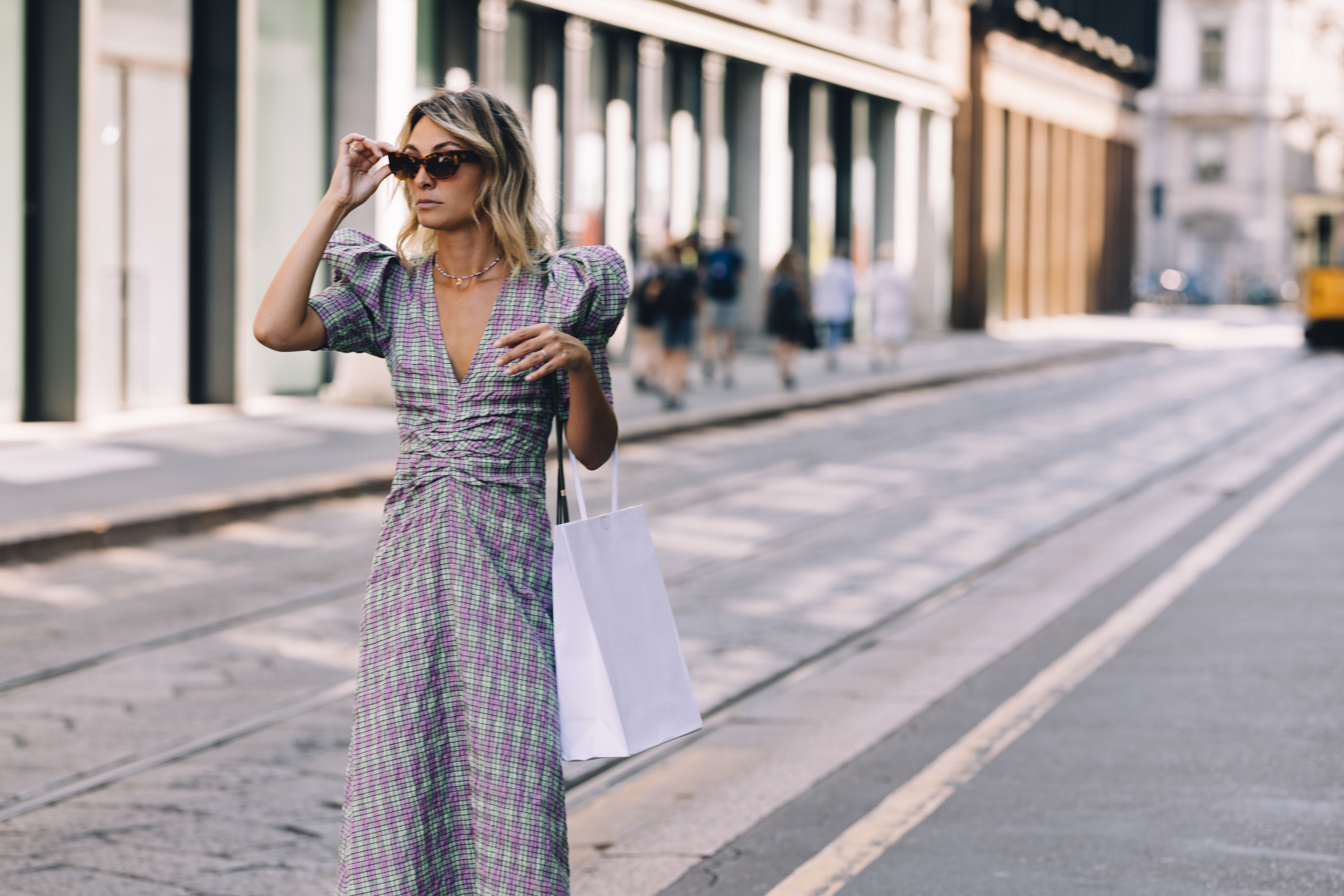 An attractive Caucasian shopaholic with a paper bag going shopping while being on vacation.