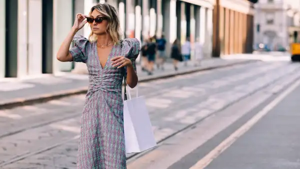 An attractive Caucasian shopaholic with a paper bag going shopping while being on vacation.
