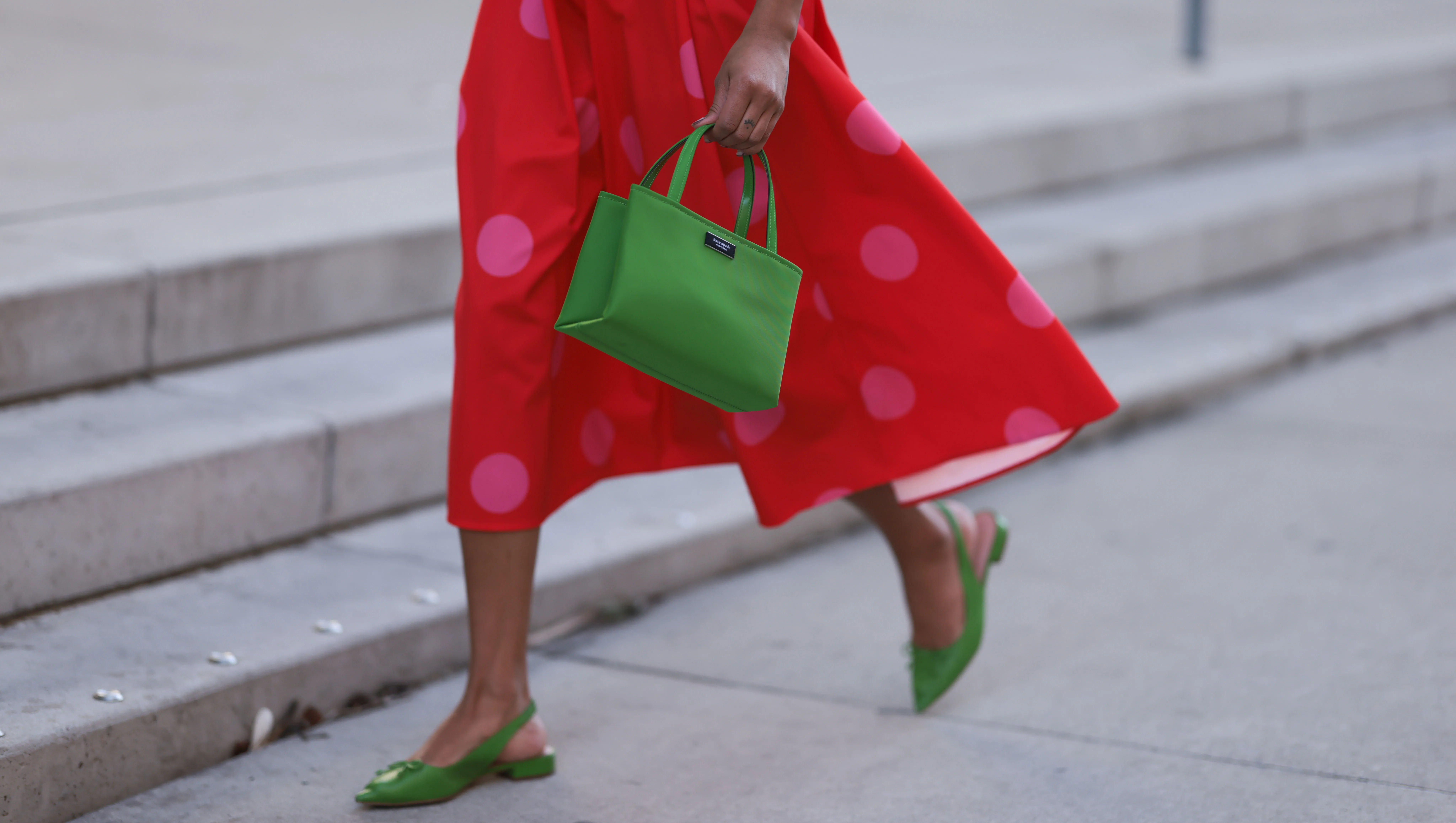 NEW YORK, NEW YORK - FEBRUARY 10: Olivia Joan seen wearing Kate Spade knit green top and cardigan, Kate Spade red long skirt with pink polka dot pattern, Kate Spate green leather bag and green leather mules before the Kate Spade presentation on February 10, 2023 in New York City. (Photo by Jeremy Moeller/Getty Images)