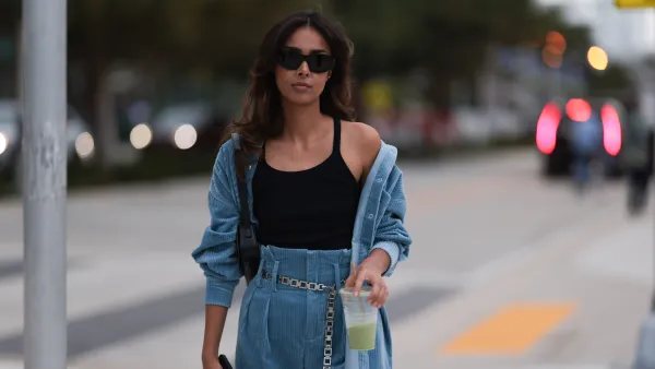 MIAMI, FLORIDA - DECEMBER 08: Paris Solati seen wearing black sunglasses, black cotton tanktop, blue corduroy two-piece / blue corduroy shirt jacket, matching blue corduroy long pants, silver chain belt, black leather shoulder bag, on December 08, 2023 in Miami, Florida. (Photo by Jeremy Moeller/Getty Images)