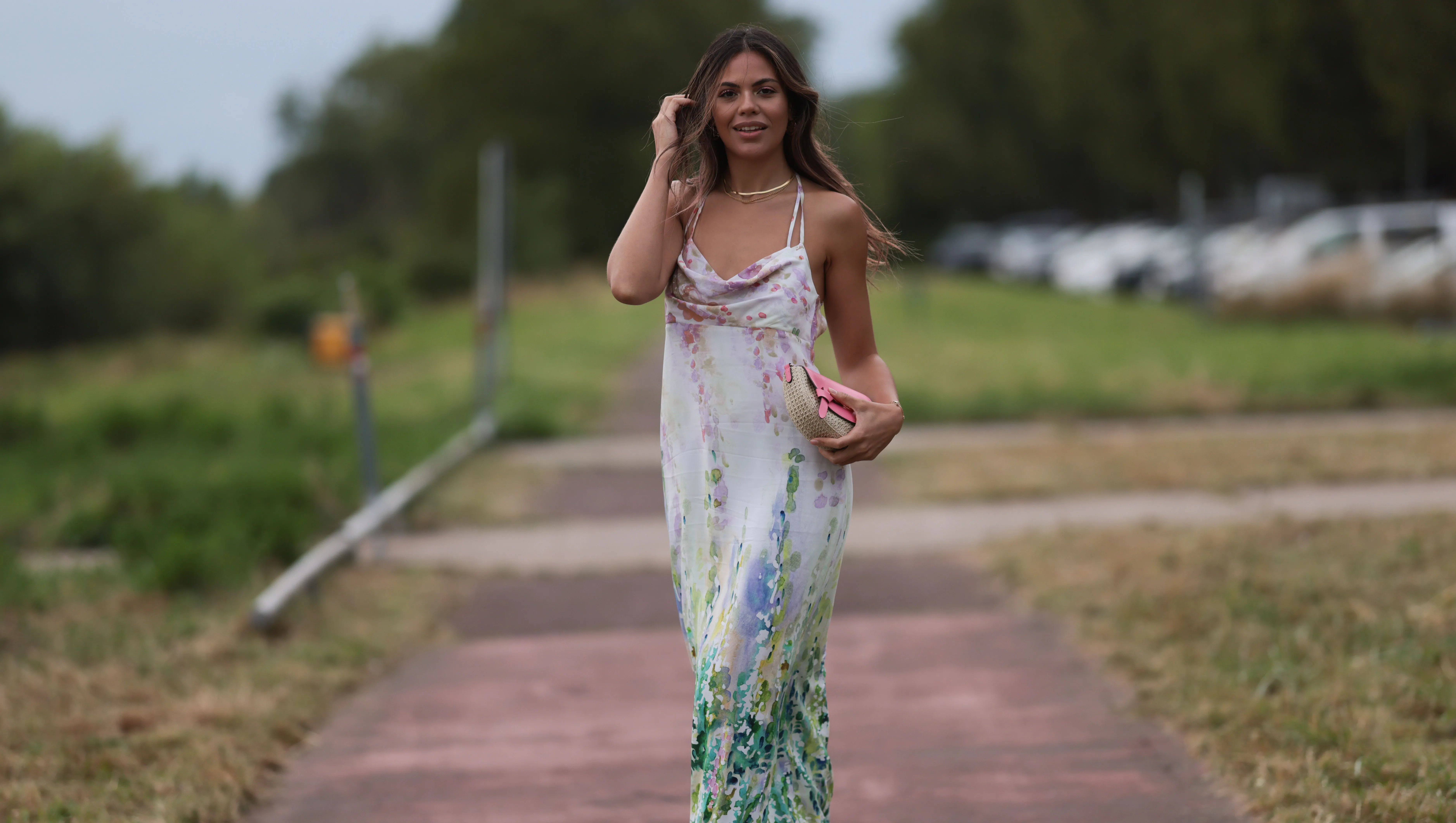 DUSSELDORF, GERMANY - JULY 22: Bruna Rodrigues is seen wearing a pastel coloured midi dress with watercolour print from Riani, a pink bag and pink strap sandals outside during the Riani Cruise 2023 on July 22, 2023 in Dusseldorf, Germany. (Photo by Jeremy Moeller/Getty Images)