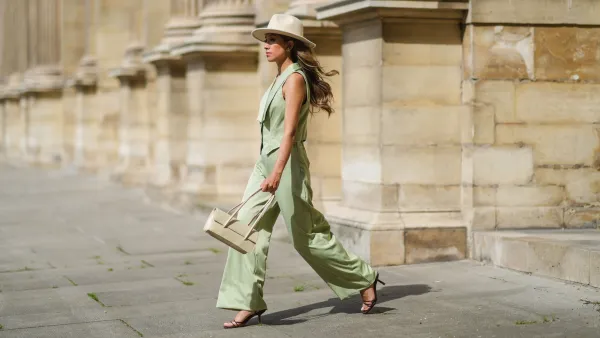 PARIS, FRANCE - MAY 29: Angela Gonzalez wears a beige suede Lack Of Color hat, earrings, a black off shoulder top, a pale green buttoned blazer jacket sleeveless from Nasty Gal, pale green matching Nasty Gal flared pants, a gold chain bracelet, a beige shiny leather Mango handbag, brown shiny leather strappy hells Na-Kd sandals, on May 29, 2021 in Paris, France. (Photo by Edward Berthelot/Getty Images)
