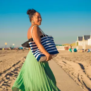 Beautiful Mixed race Woman wearing a long dress on the beach - stock photo