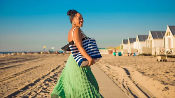 Beautiful Mixed race Woman wearing a long dress on the beach - stock photo