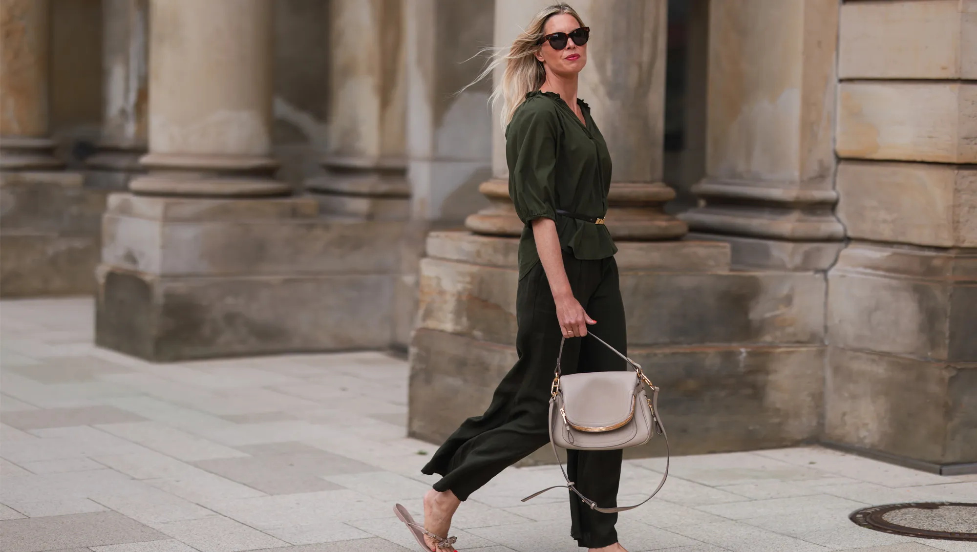 Vanessa Gieser seen wearing a brown Celine sunglasses, khaki blouse from SoSue, a matching khaki pants from SoSue, a beige leather Tom Ford bag, a black Celine belt and beige Valentino sandals on June 09, 2022 in Hamburg, Germany.