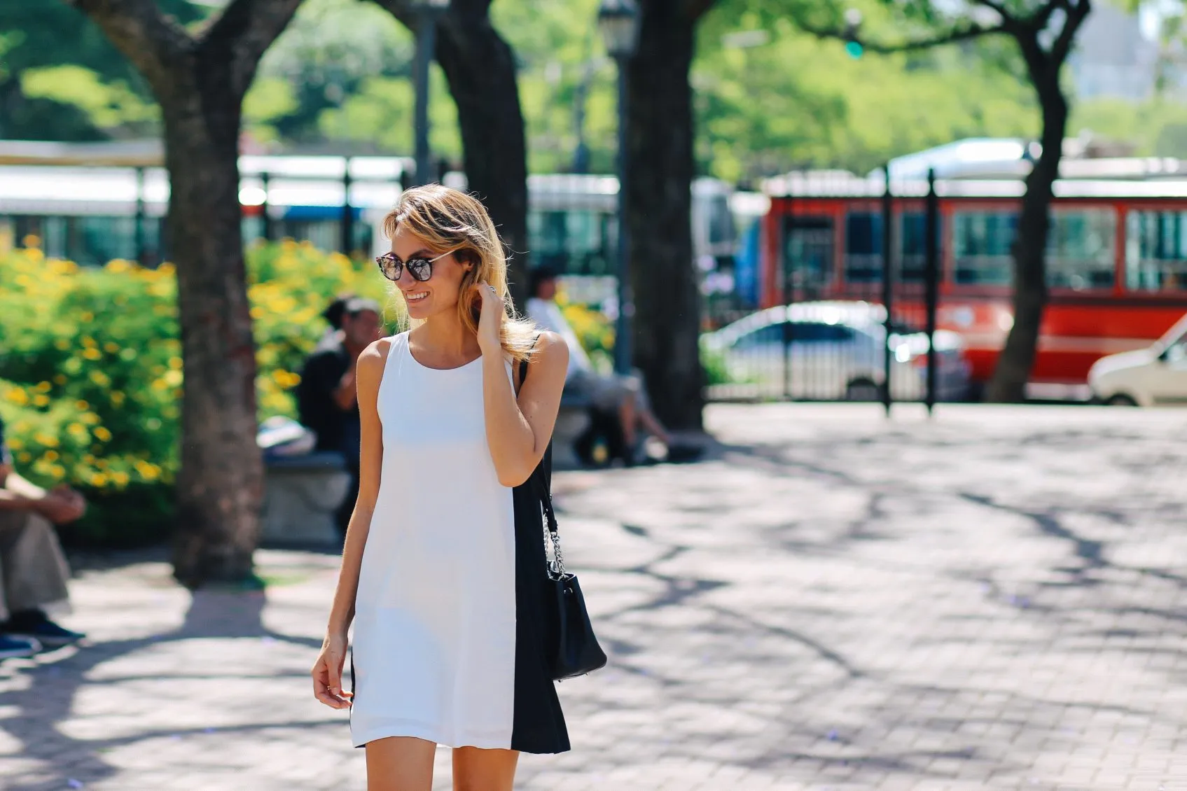 Woman smiling and enjoying the sun while strolling in the park, Buenos Aires, Argentina.