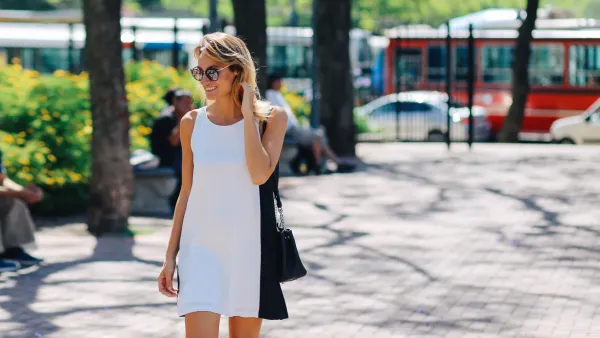 Woman smiling and enjoying the sun while strolling in the park, Buenos Aires, Argentina.