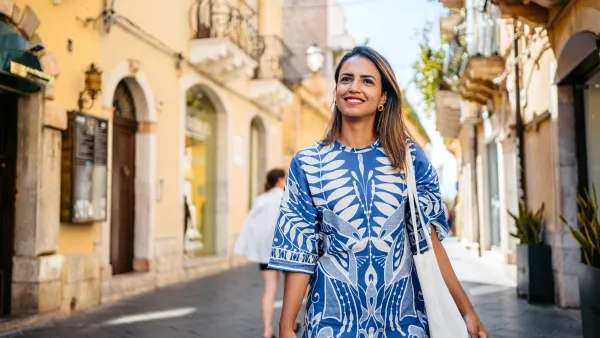 Beautiful young Brazilian woman walking on town square in Taormina in Sicily.