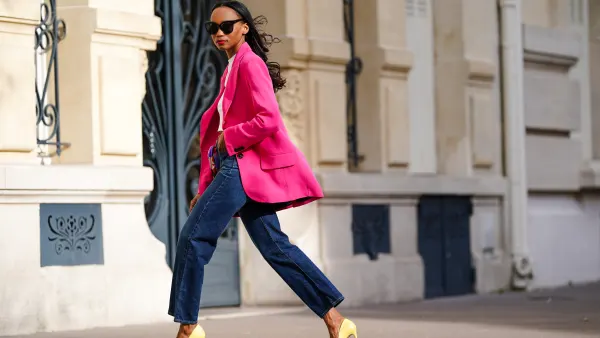 Emilie Joseph @in_fashionwetrust wears sunglasses, a bright neon pink oversized blazer jacket from Zara, a white crew neck crop top from H&M, high rise ribcage straight blue jeans in dark indigo from Levi's, a silk floral multicolor printed scarf worn as a belt from Kenzo, yellow high heels pointy stilettos shoes from Cosmoparis, on March 21, 2021 in Paris, France.